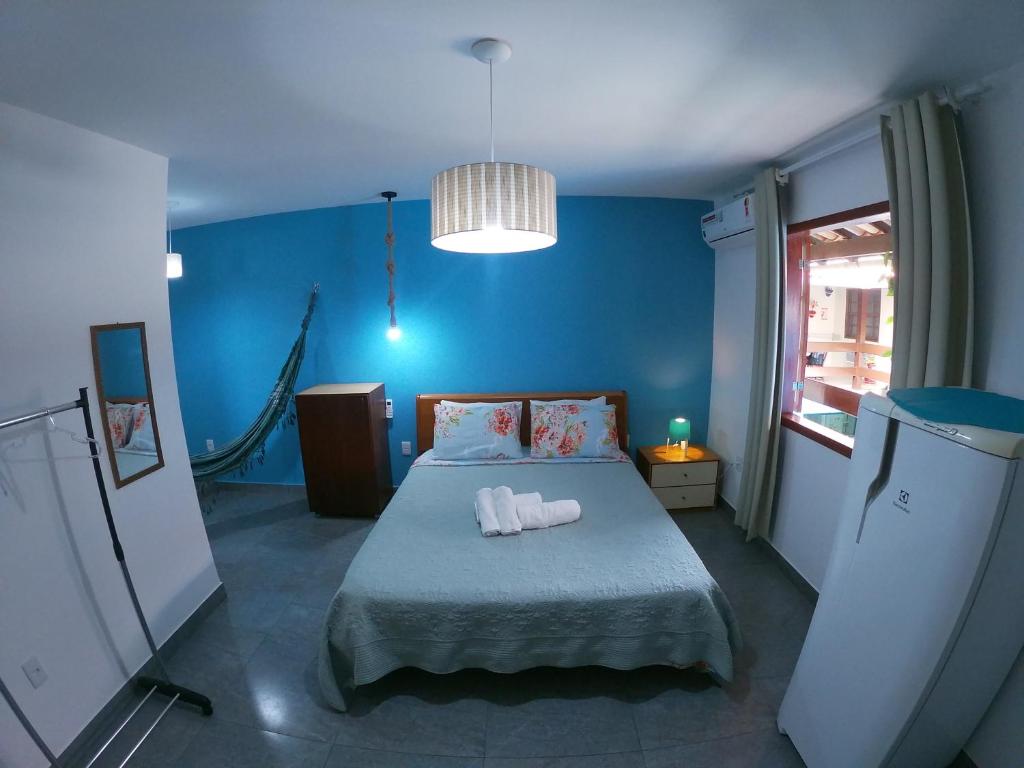 Un dormitorio azul con una cama con toallas. en Pousada Melodia do Mar en Cabo Frío