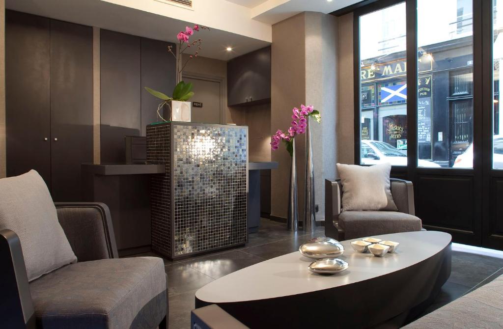 a lobby with a coffee table and chairs at Hôtel Caron le Marais in Paris