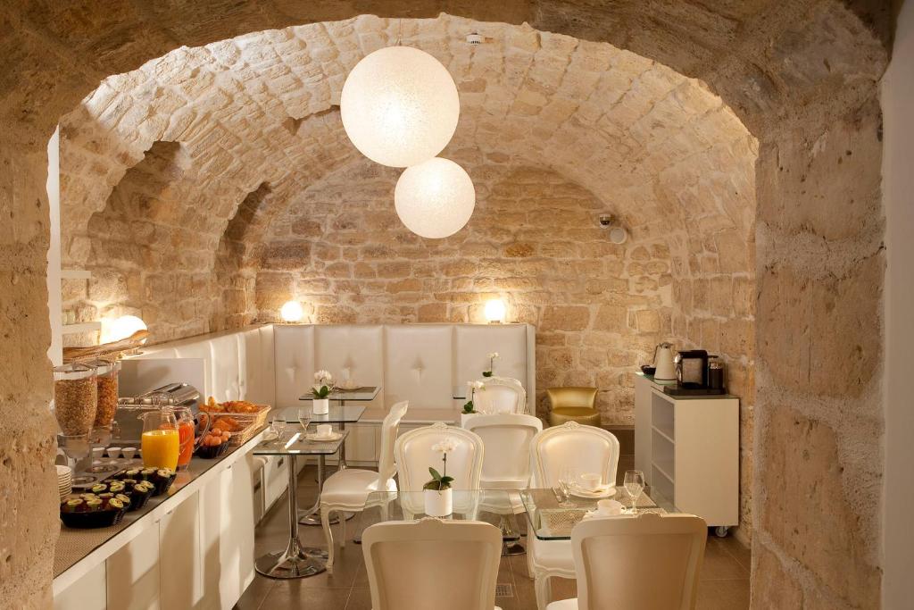 een eetkamer met een tafel en witte stoelen bij Hôtel Caron le Marais in Parijs