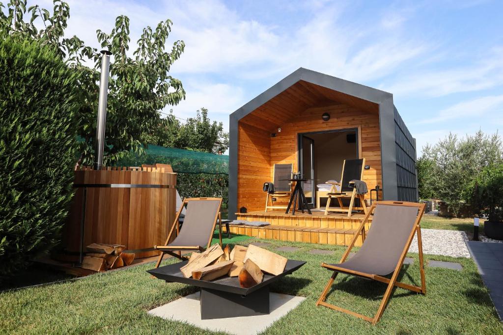 a tiny house in a garden with two chairs at Healthy House Glamping in Koper
