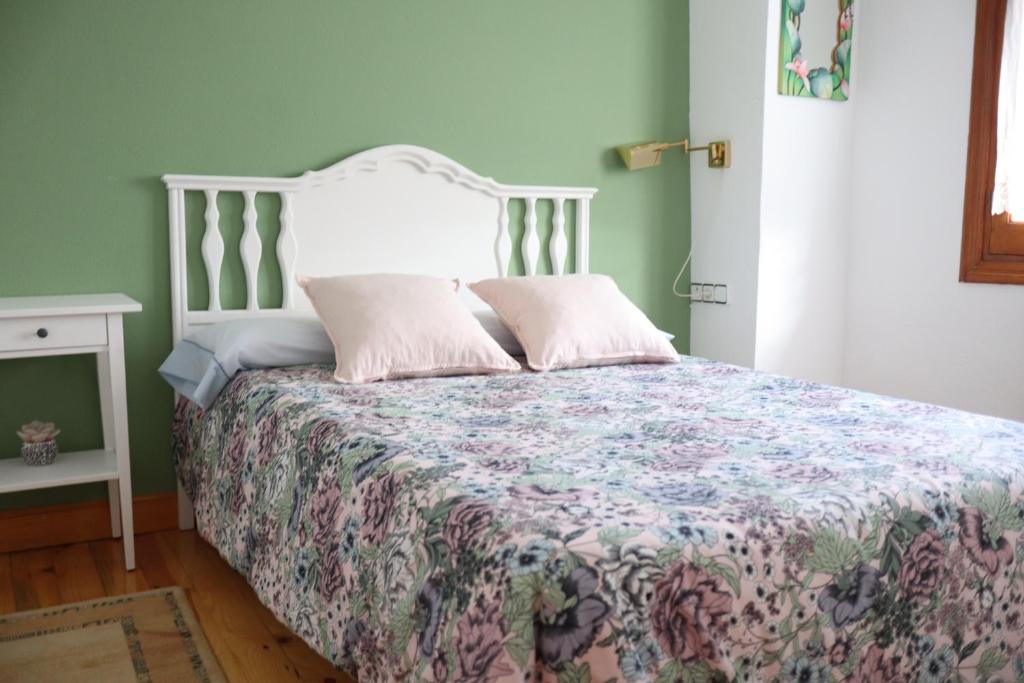 a bedroom with a bed with a floral bedspread at El Mirador 2 in Paralacuesta