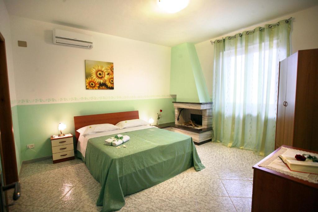 - une chambre avec un lit vert et une cheminée dans l'établissement A Casa Di Giordy, à Castro di Lecce