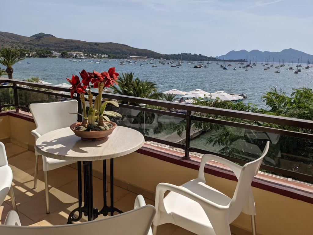 balcone con tavolo, sedie e vista sull'acqua di Casa Es Mestral blue a Port de Pollença