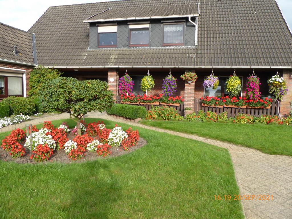 a house with a garden of flowers in the yard at Schmidtfewo Moorgeist in Bockhorn