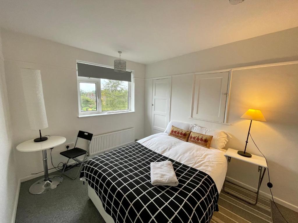 a bedroom with a black and white bed and a window at Golden Triangle House in Norwich