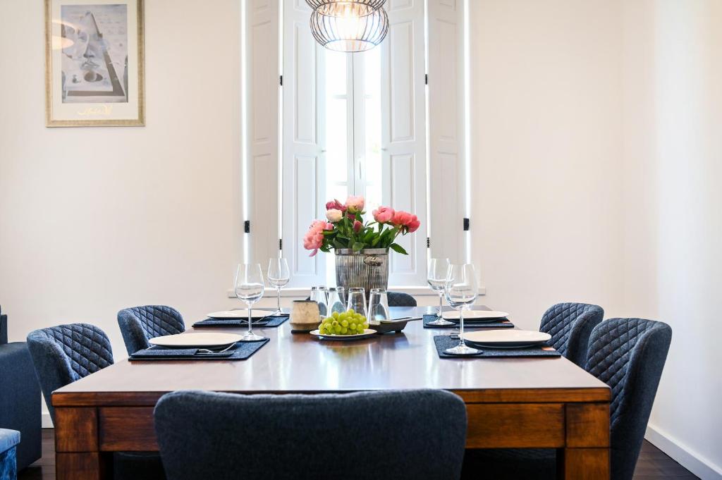 une table à manger avec des chaises et un vase de fleurs dans l'établissement Insel-Apartment im Herrenhaus Rheinblick, à Xanten