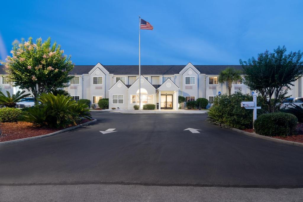 un gran edificio blanco con una bandera americana delante en Microtel Inn & Suites by Wyndham Savannah/Pooler, en Savannah