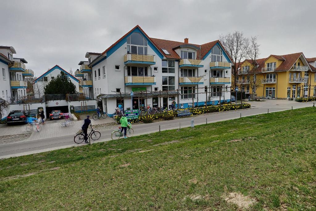 two people riding bikes down a street with buildings at Residenz "Am Strand", Whg 8 in Zingst