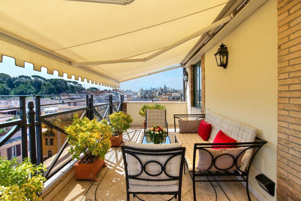 einen Balkon mit einem Tisch, Stühlen und Pflanzen in der Unterkunft River Palace Hotel in Rom