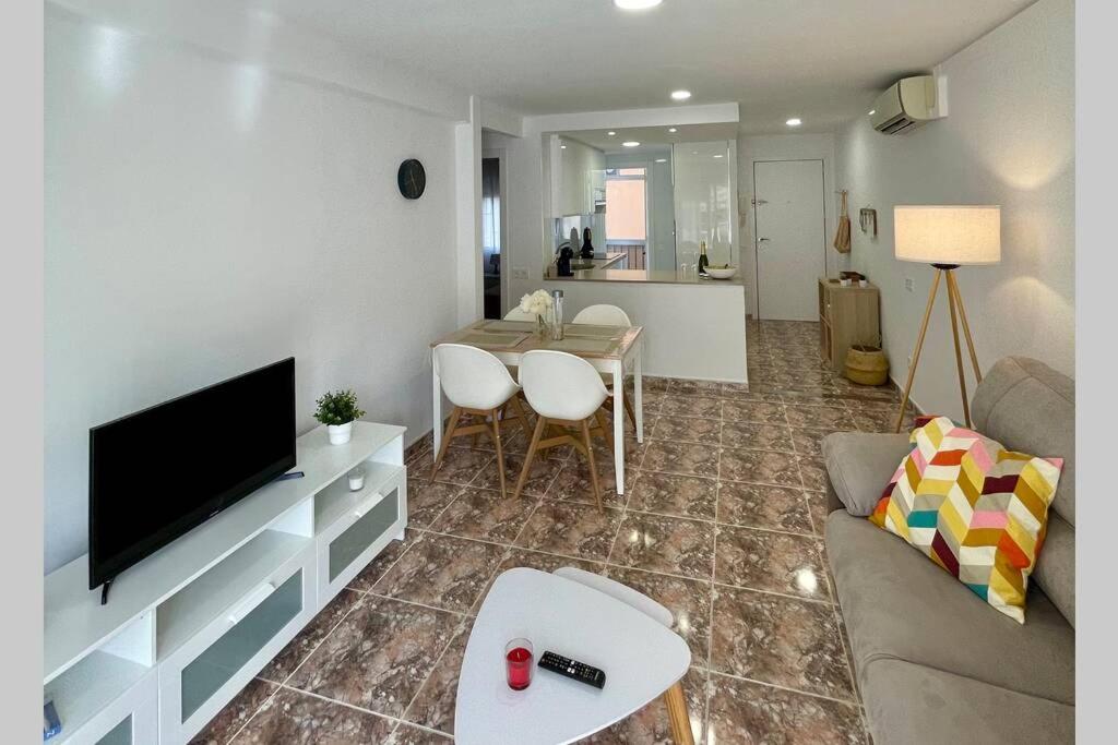 ein Wohnzimmer mit einem Sofa, einem TV und einem Tisch in der Unterkunft Holiday apartment in Salou
