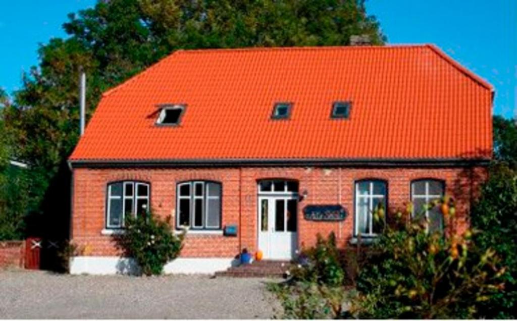 ein kleines rotes Backsteinhaus mit orangefarbenem Dach in der Unterkunft Alte Schule Wenkendorf Nr2 in Wenkendorf
