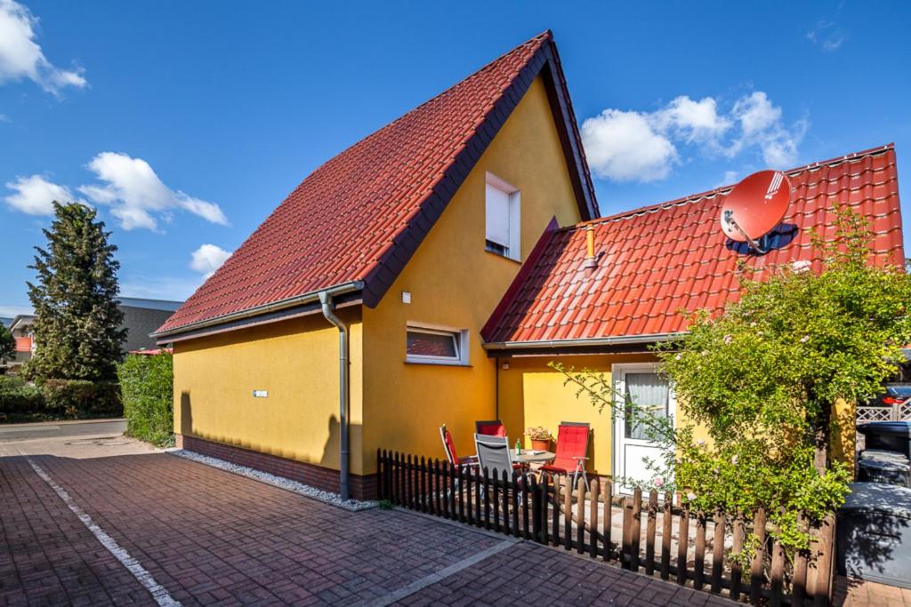 uma casa amarela com um telhado vermelho em Haus Max em Grömitz