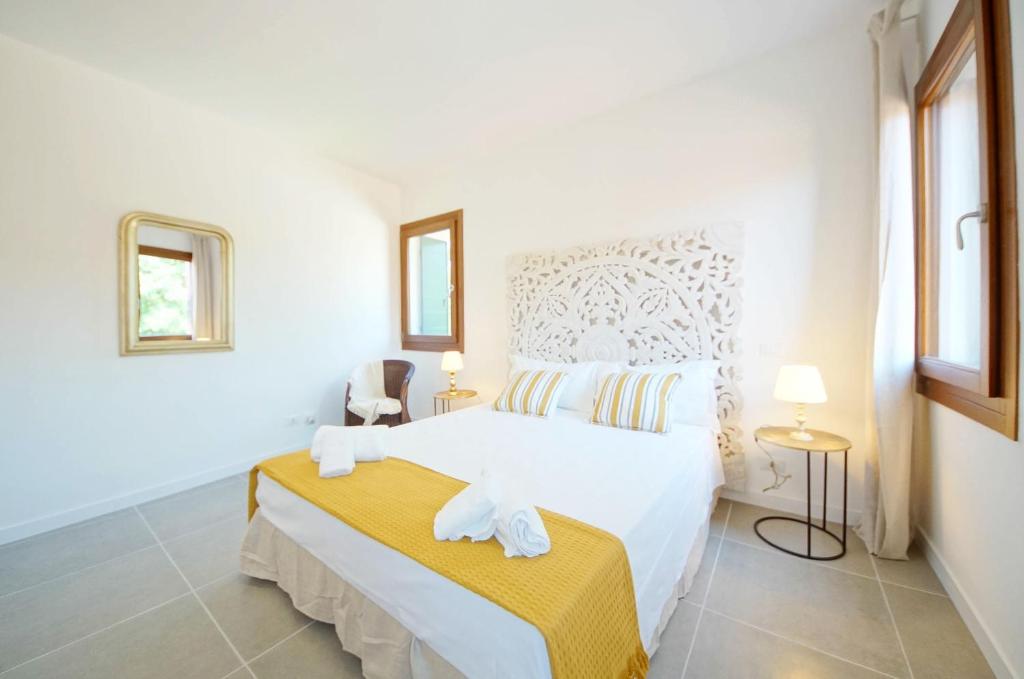 a white bedroom with a bed and two windows at DolceVita Apartments N. 491 Biennale in Venice