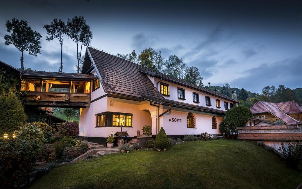 a large white house with a gambrel roof at Penzion U Sovy in Dolný Kubín