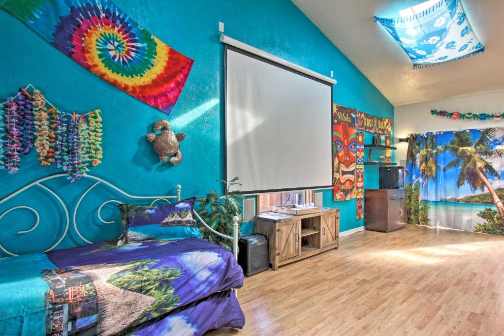 a bedroom with a blue wall with a bed and a large window at Springfield Tiki Home Hot Tub and Theater Room in Springfield