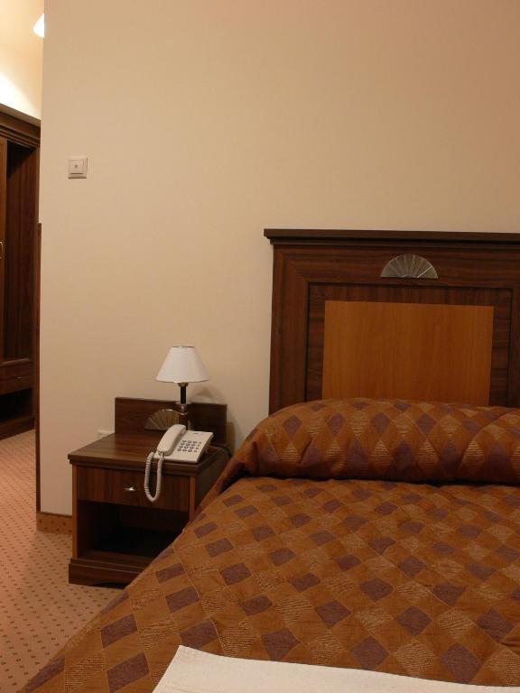 A bed or beds in a room at Öreg Miskolcz Hotel