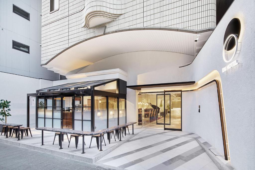 福岡市にあるエンホテル博多の外にテーブルとベンチがある建物