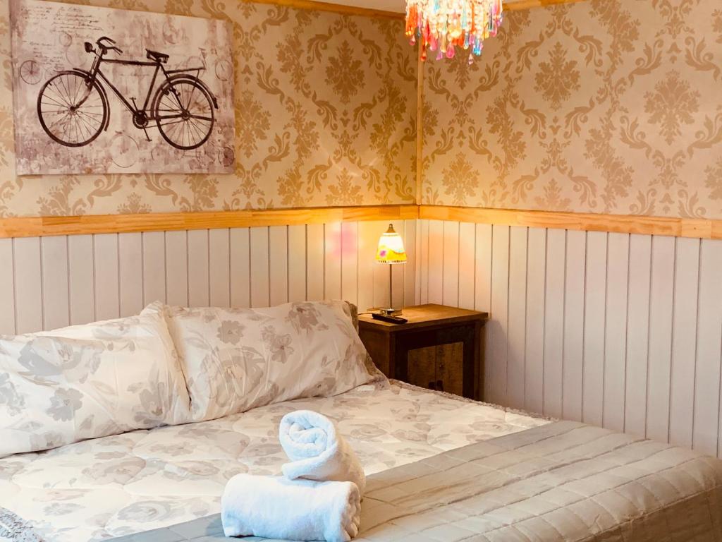 1 dormitorio con 1 cama con una bicicleta en la pared en Arte Brisa Hostal Boutique, en Puerto Natales