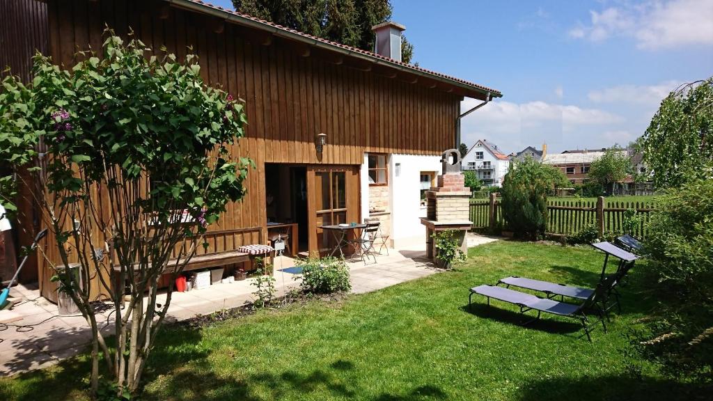 un jardín con una casa de madera y un banco en Ferienhaus Spazzacamino, en Bad Grönenbach
