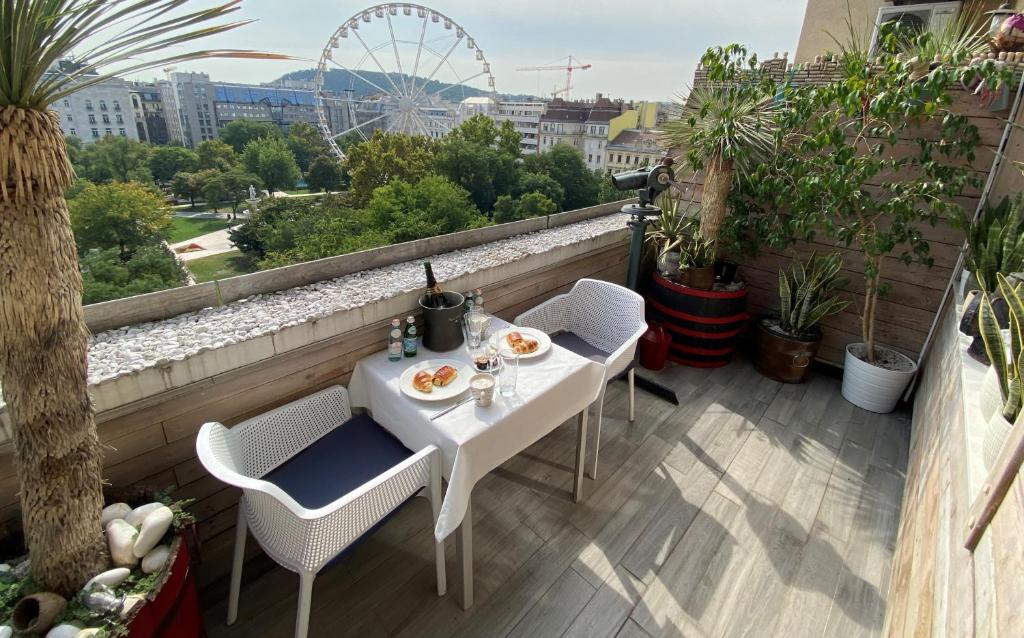 einen weißen Tisch und Stühle auf einem Balkon mit einem Riesenrad in der Unterkunft Vista Suites 1-2 in Budapest