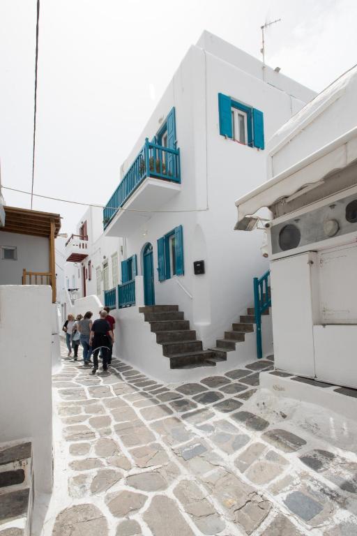 a group of people walking down a street with a building at Florance Apartments & Rooms in Mikonos