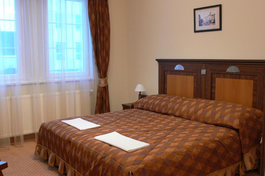 A bed or beds in a room at Öreg Miskolcz Hotel