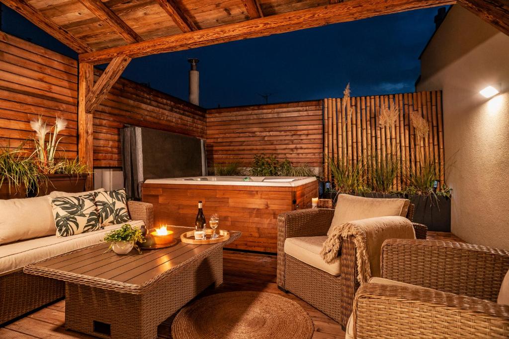 eine Terrasse mit einer Badewanne, einem Tisch und Stühlen in der Unterkunft Sting Old Town Ostrava in Ostrava