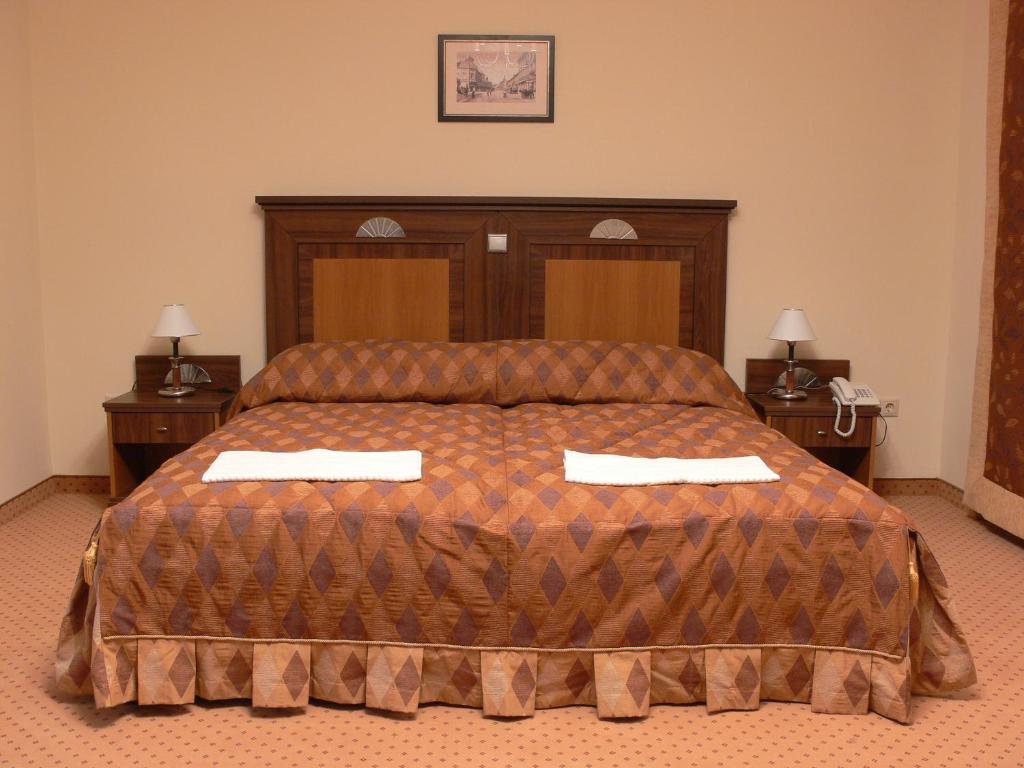 A bed or beds in a room at Öreg Miskolcz Hotel
