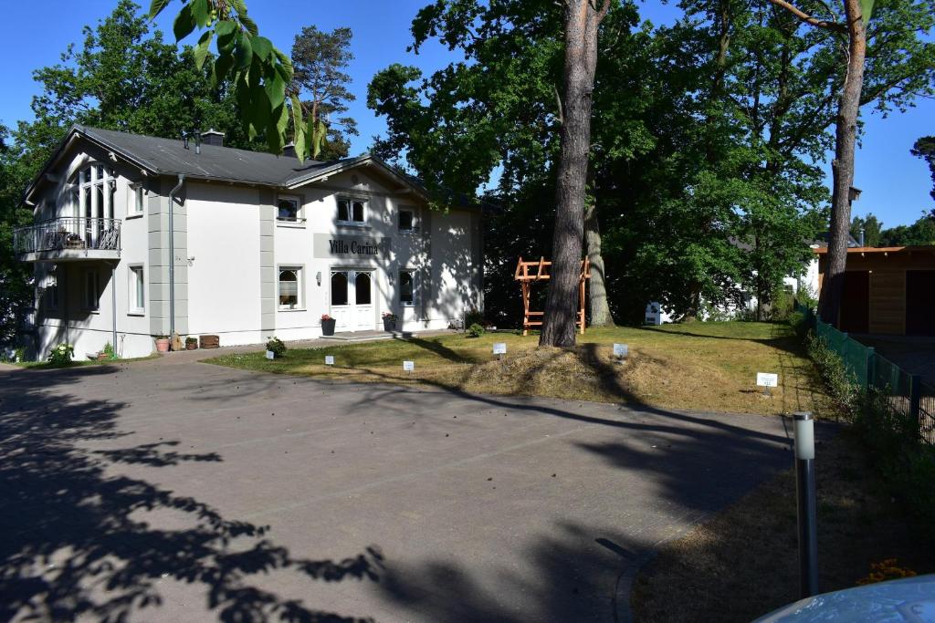 a white house with a tree next to a driveway at Villa Carina "Carina`s 911" in Baabe