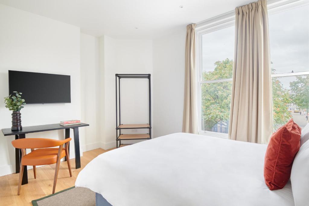 a bedroom with a bed and a desk and a window at Sonder The Prince, Vauxhall in London
