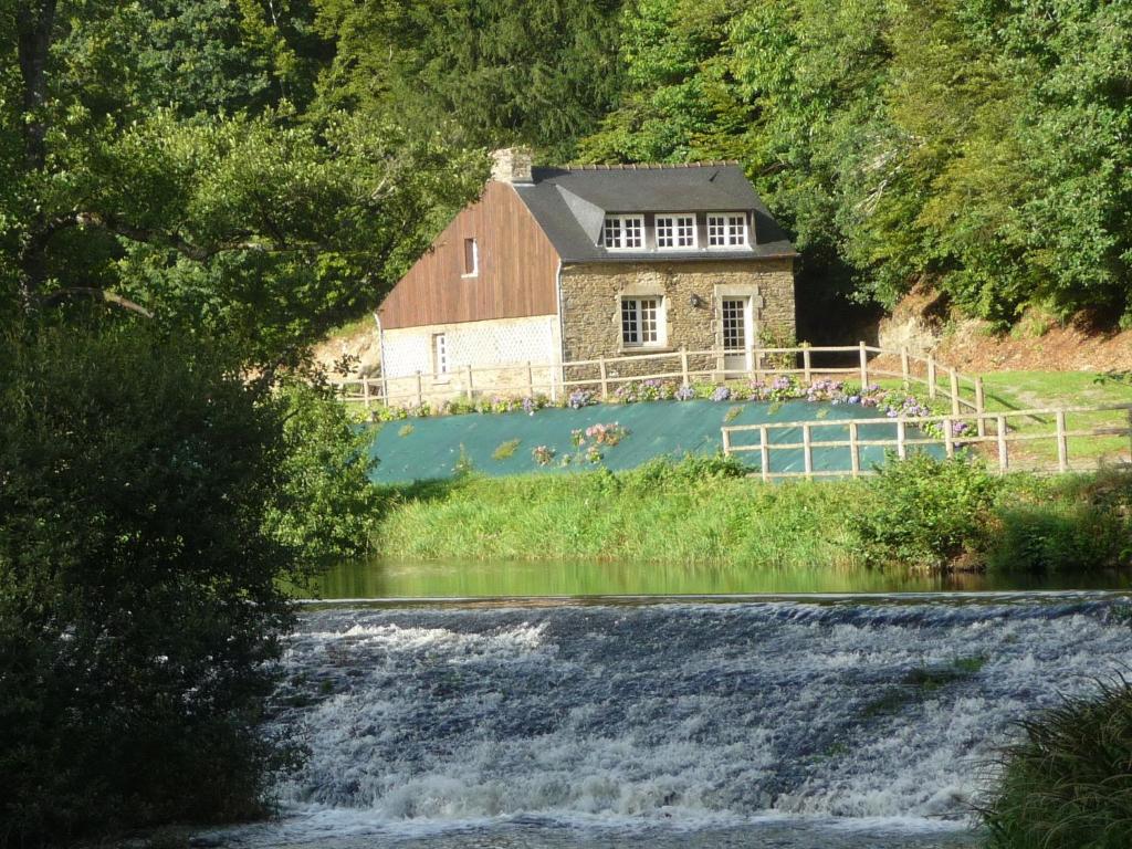 a house on a hill next to a river at Domaine de Pratulo in Cléden-Poher