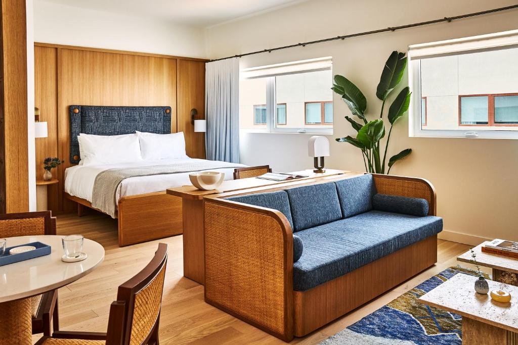 een hotelkamer met een bed en een blauwe bank bij Alsace LA in Los Angeles