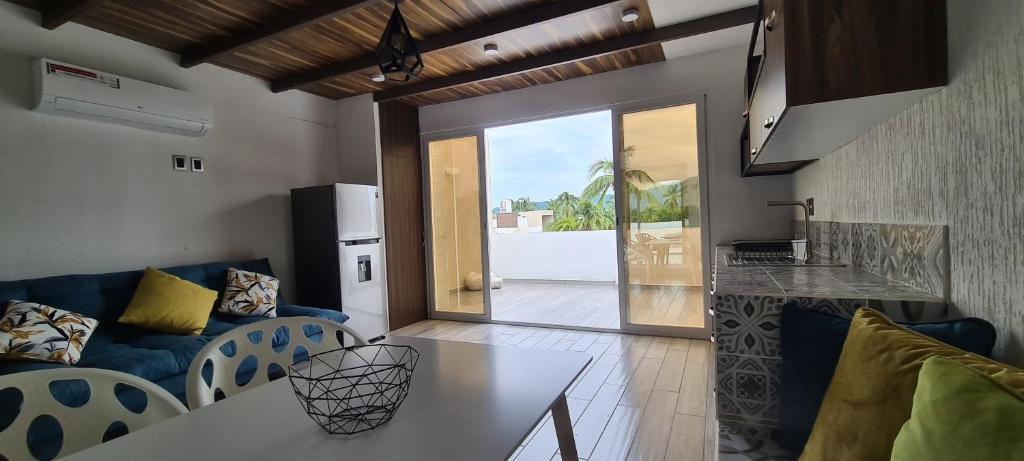 een woonkamer met een bank en een tafel bij Moderno depa con terraza y vista extraordinaria in Manzanillo