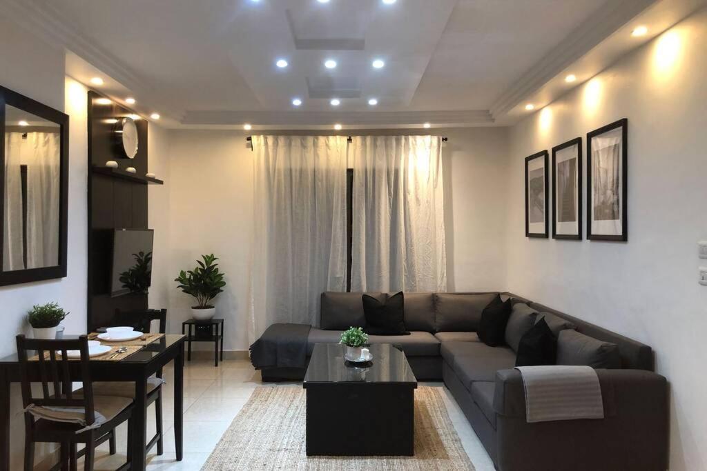 ein Wohnzimmer mit einem Sofa und einem Tisch in der Unterkunft Luxury Apartment in Awesome Location in Amman in Amman