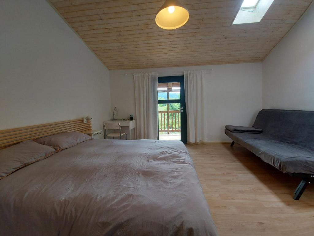 a bedroom with a large bed and a couch at Apartmaji Hedera in Komen