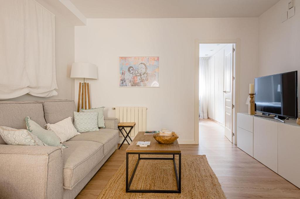 ein Wohnzimmer mit einem Sofa und einem TV in der Unterkunft Charming Avenida América in Madrid