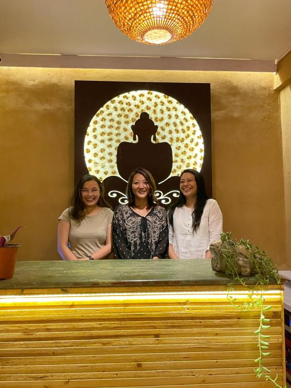 a group of three women standing behind a counter at Mellow Fellow Hostel in Gangtok