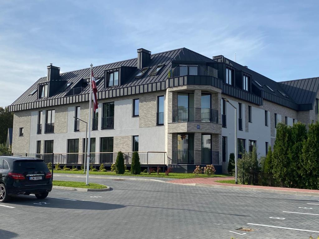 a large building with a flag in front of it at Zane's apartment in Valmiera