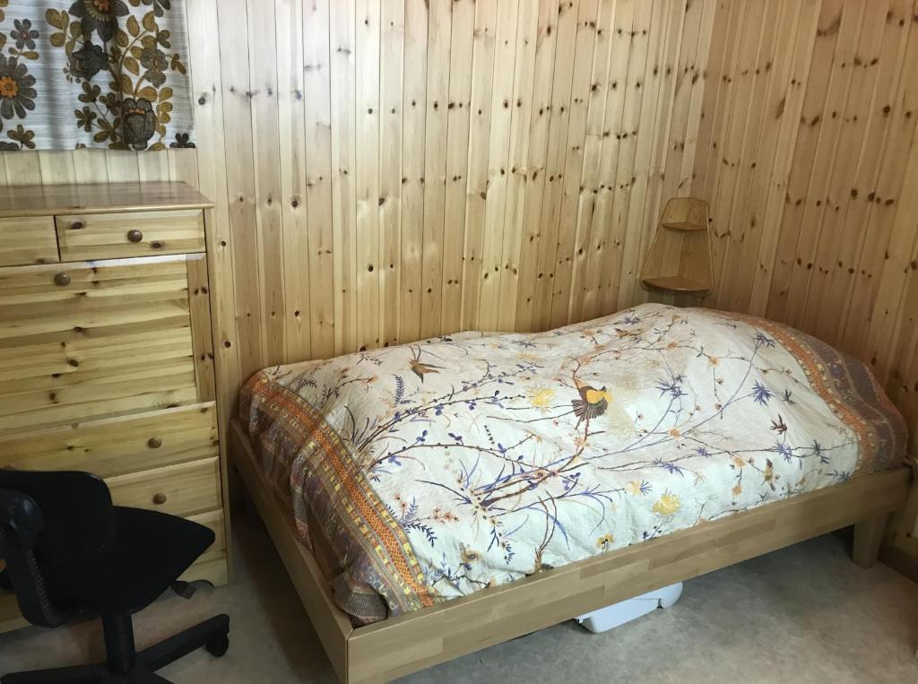 een slaapkamer met een bed, een bureau en een stoel bij Ferienwohnung im Chalet Boubou in Wiler