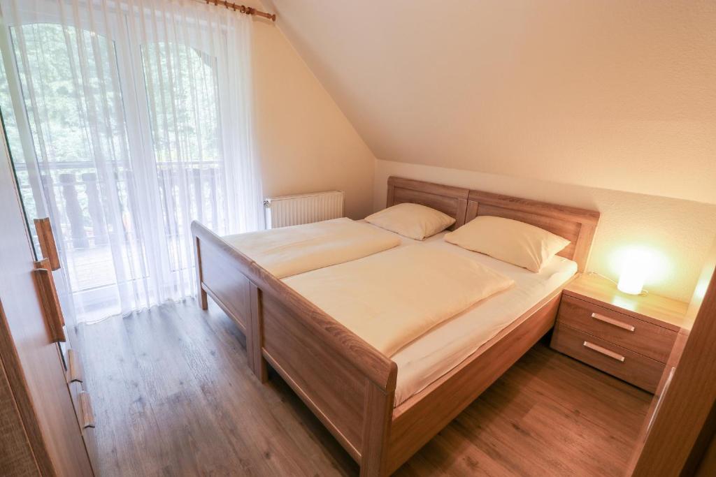 - une chambre avec un lit et une grande fenêtre dans l'établissement Familienhof Brüning - Waldblick, à Meppen