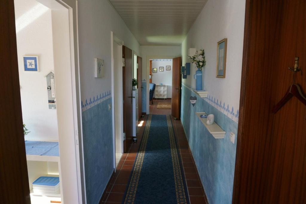 a hallway with blue and white walls and a bathroom at Carpe Diem III 1323 in Landkirchen