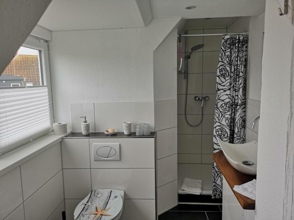 een badkamer met een douche, een toilet en een wastafel bij Black Pearl in Schönberger Strand