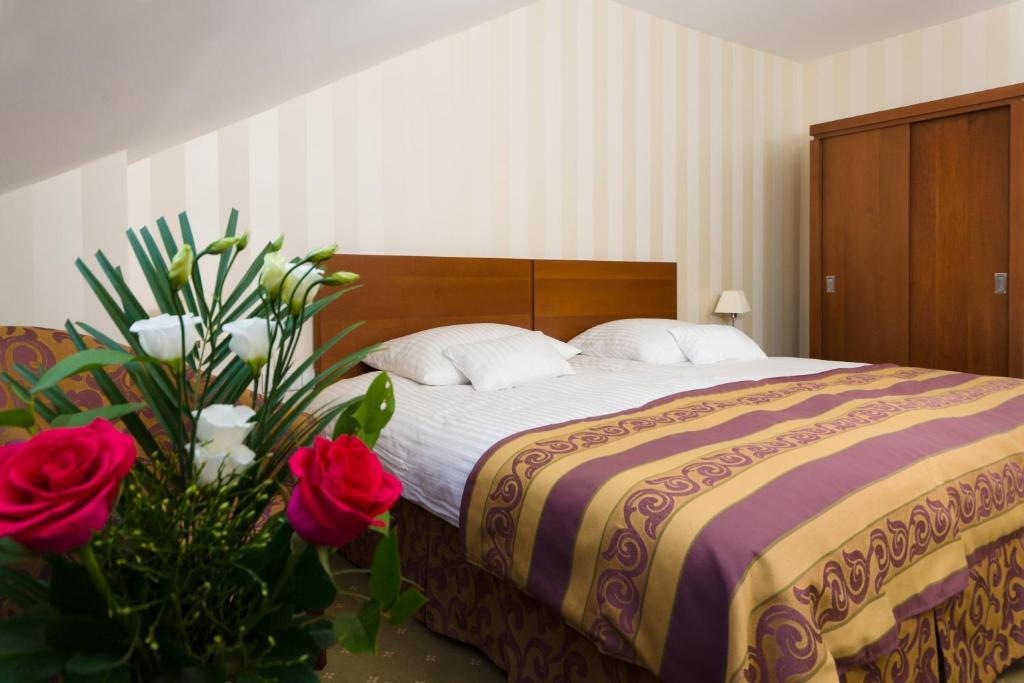 a bedroom with a bed with red roses and flowers at Pension Palazzo in Sibiu