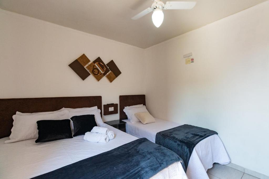 a bedroom with two beds and a ceiling fan at Brás - APARTAMENTO ACONCHEGANTE in Sao Paulo