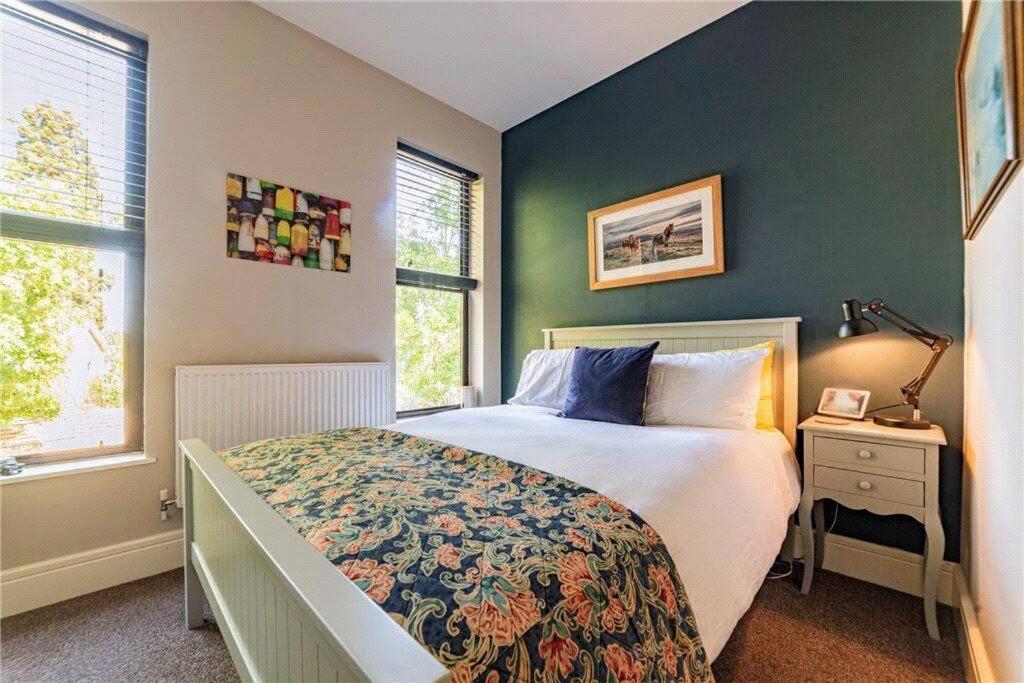 a bedroom with a bed and a green wall at Perfect for Legoland, Windsor Castle and Ascot with free parking in Windsor