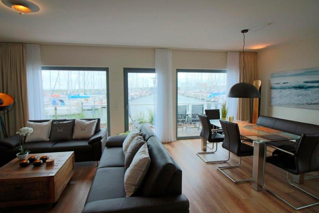een woonkamer met een bank en een tafel bij Ostsee - Ferienhaus Nr 29a "Erste Reihe" im Strand Resort in Heiligenhafen