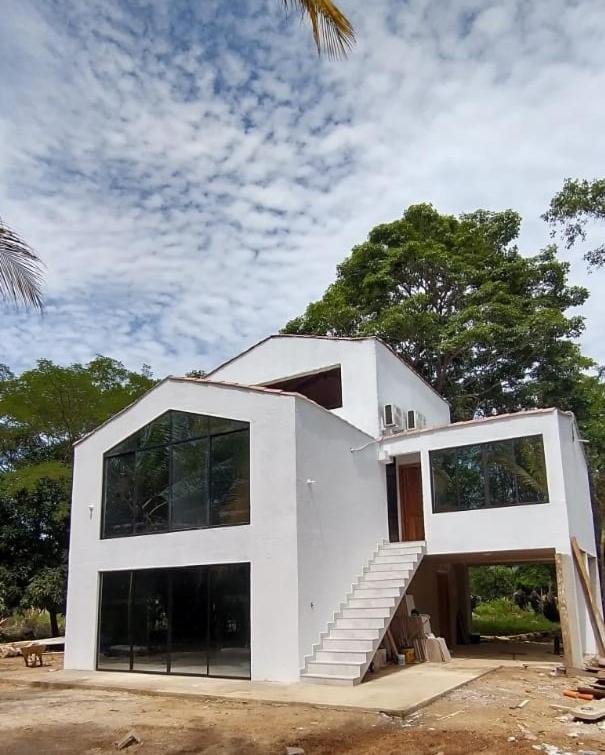 a white house with a staircase in front of it at Cabañas El Olimpo in Necoclí