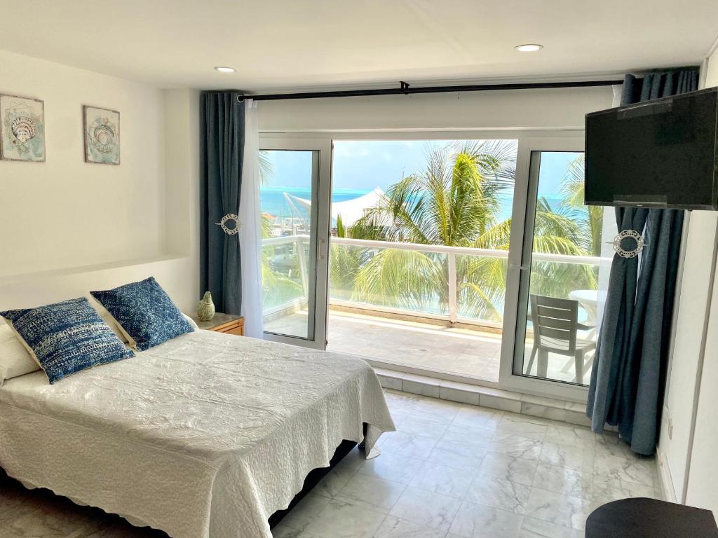 una camera con un letto e una grande porta scorrevole in vetro di Exclusivos Apartamentos con playa privada a San Andrés