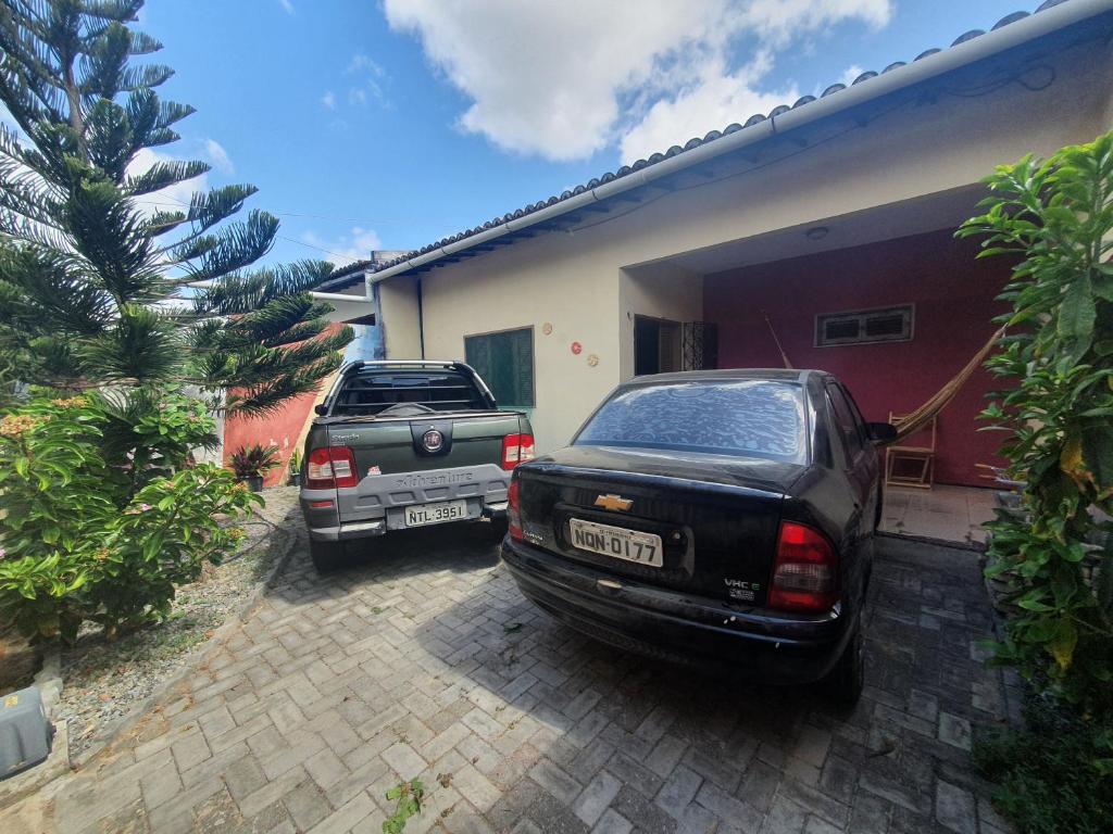 zwei Autos, die vor einem Haus geparkt sind in der Unterkunft Casa de praia, Camocim. in Camocim