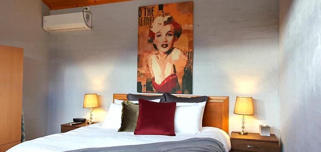 Great Escape Lofts في غلوستر: غرفة نوم بسرير مع لوحة على الحائط